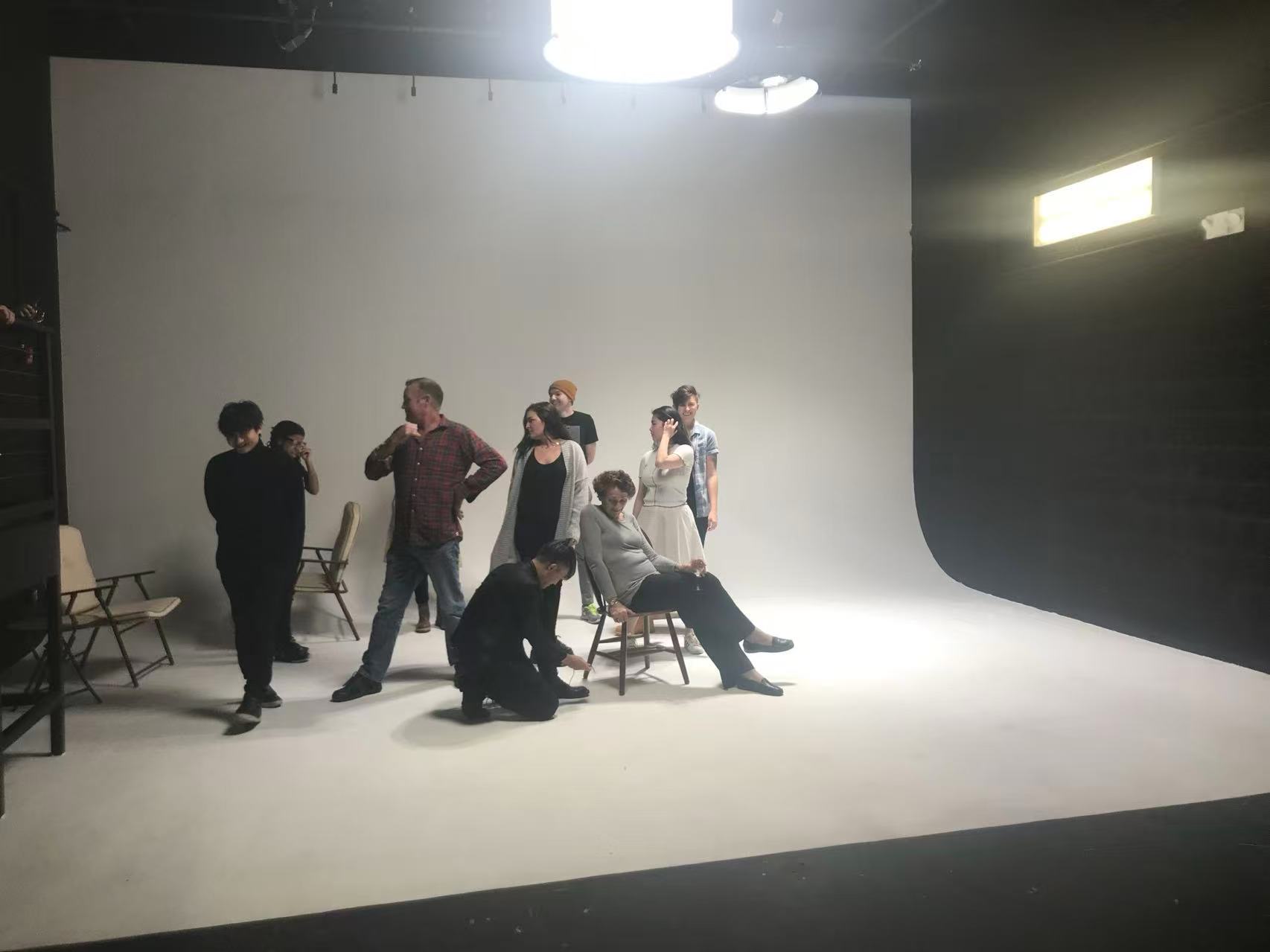 Cast and crew gathered on a white studio cyclorama