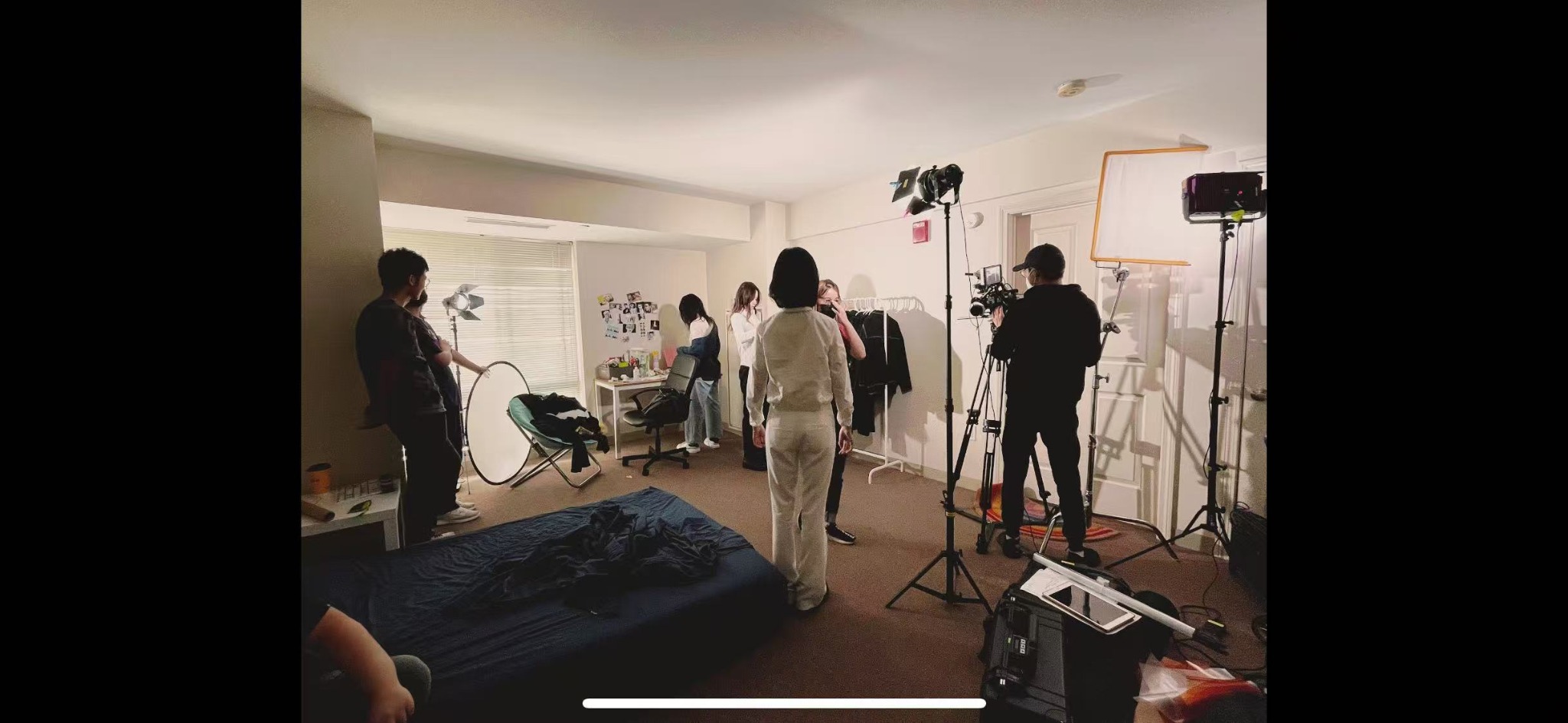 Cast and crew preparing an interior scene with lights and camera