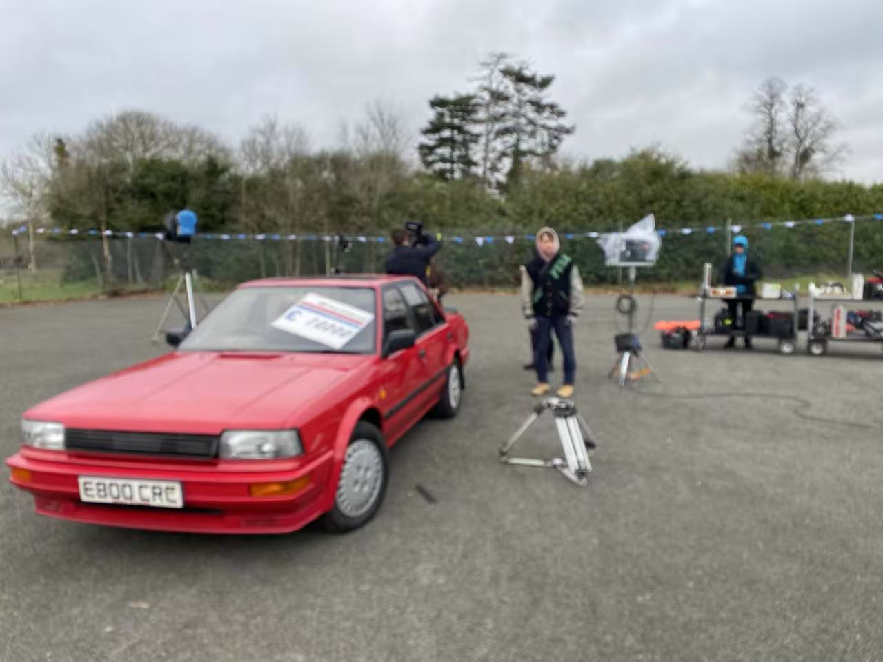 Red car and camera equipment on an outdoor set